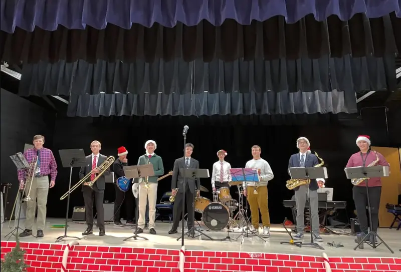 The full Scholars lineup in Santa hats taking a bow after a holiday concert
